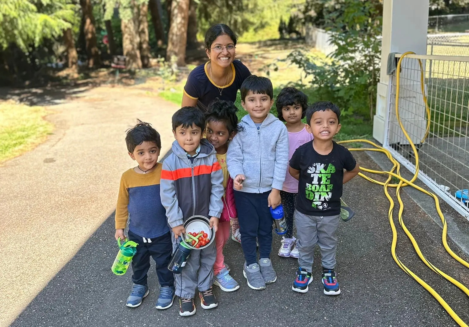 A group of children with their teacher on the school driveway