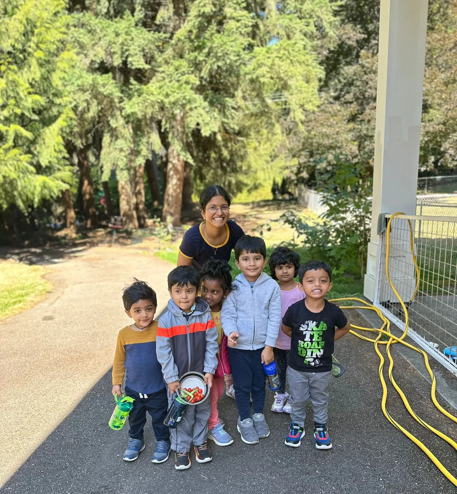 Children and their teacher outside the school on a sunny day