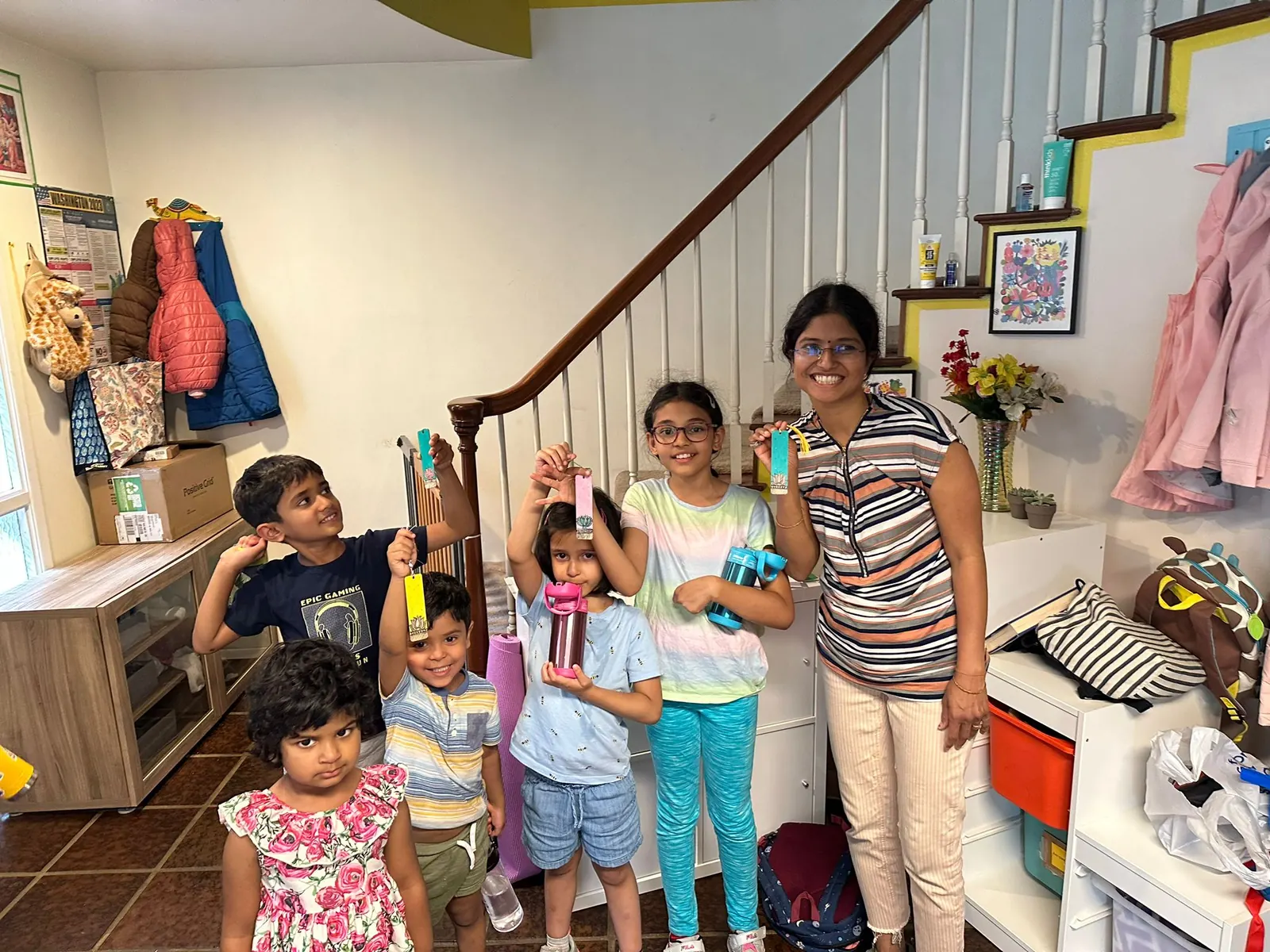 Children and a teacher smiling together in the school hallway