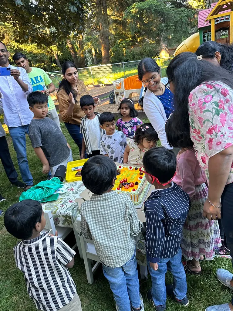 Children and families crowding round to cut the graduation cake