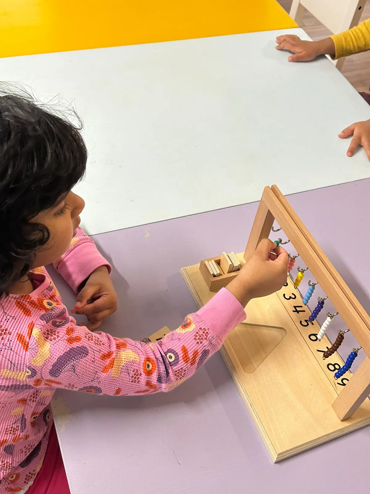A child working with a wooden counting material