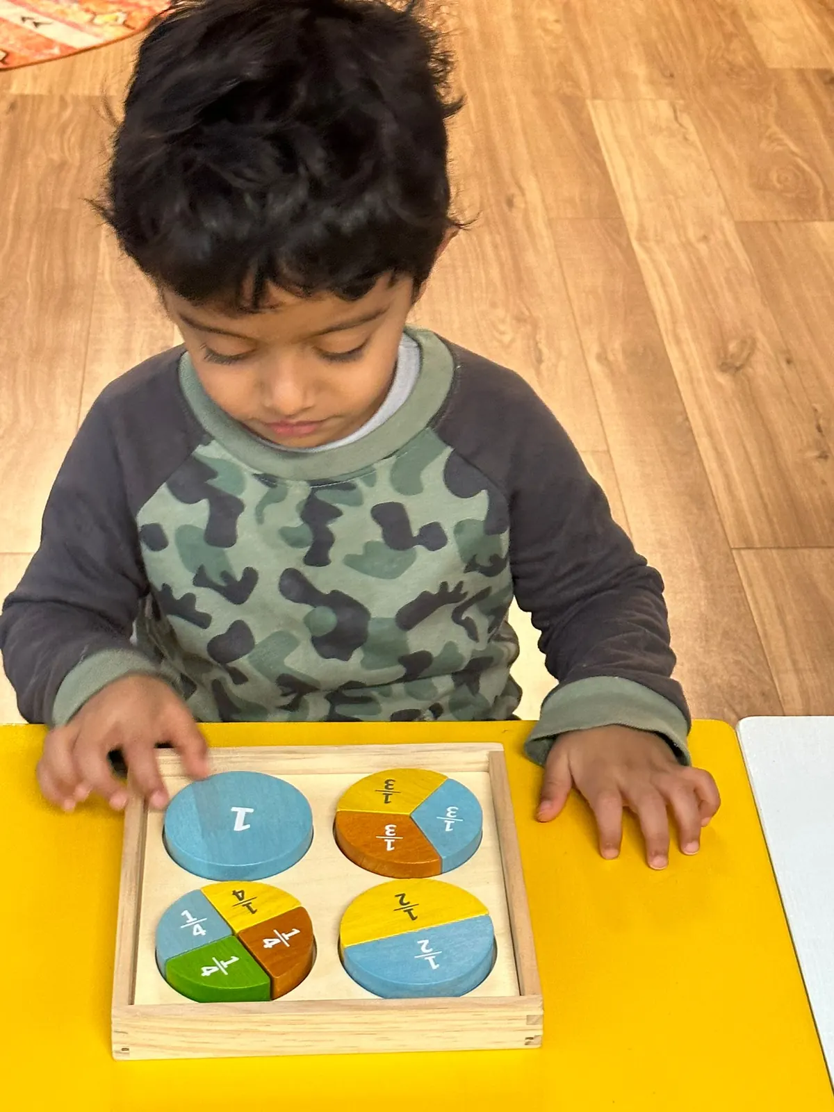 A child fitting pieces into the fraction circles
