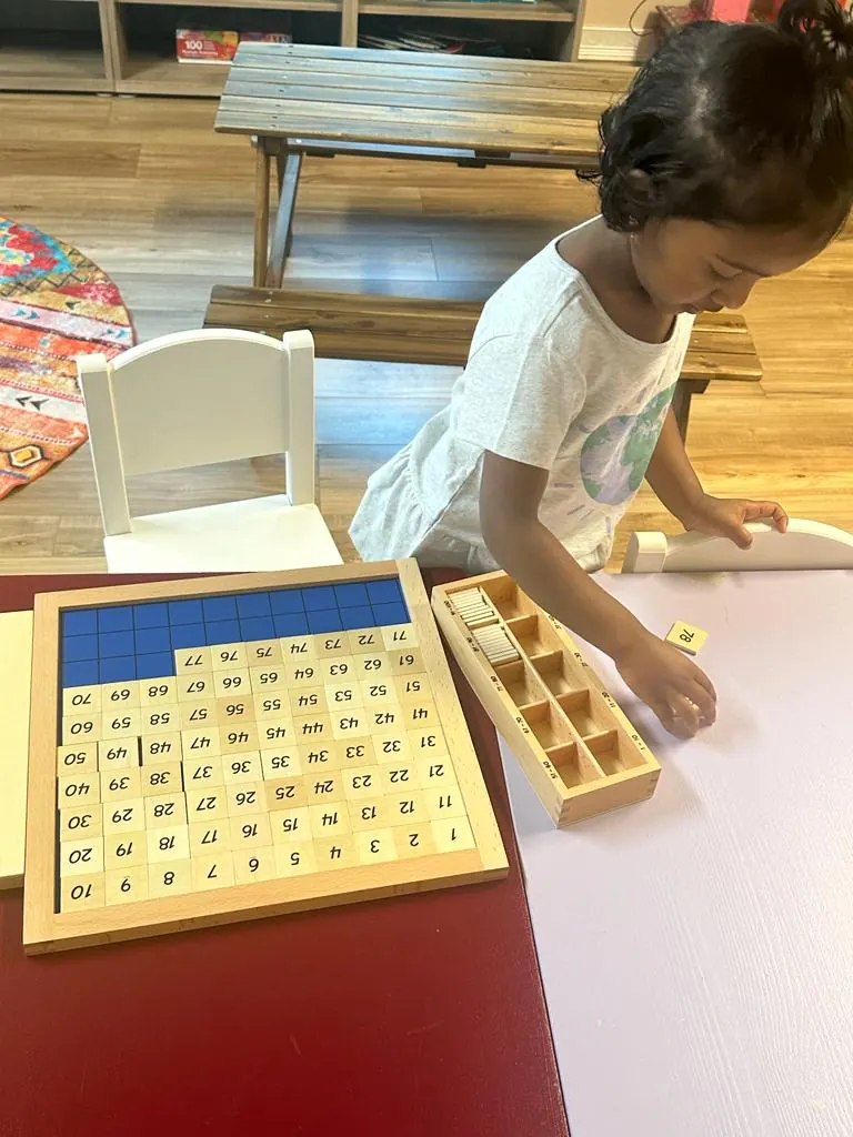 A child placing tiles on the hundred board