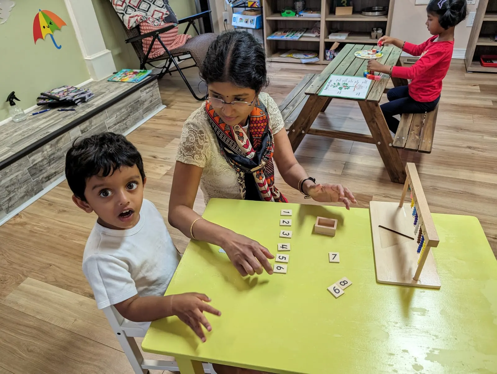 A teacher helping a child put number cards in order