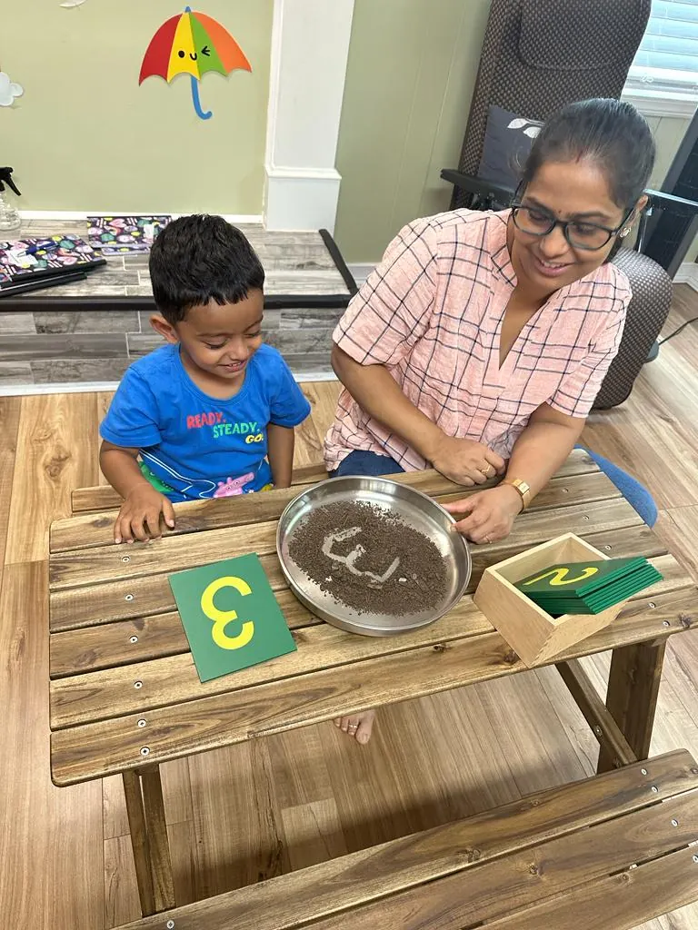 A teacher and child tracing a sandpaper number