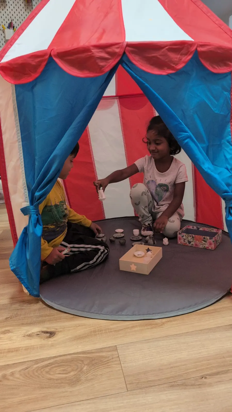 A child playing quietly inside a play tent