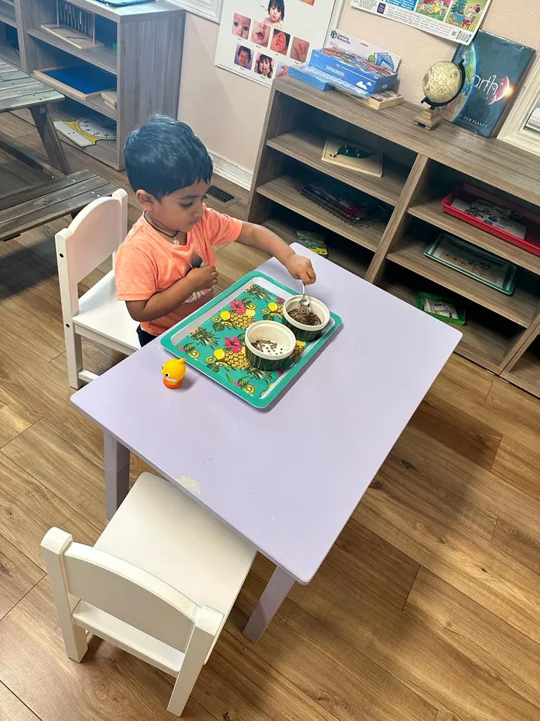 A child working with a tray activity at a low table