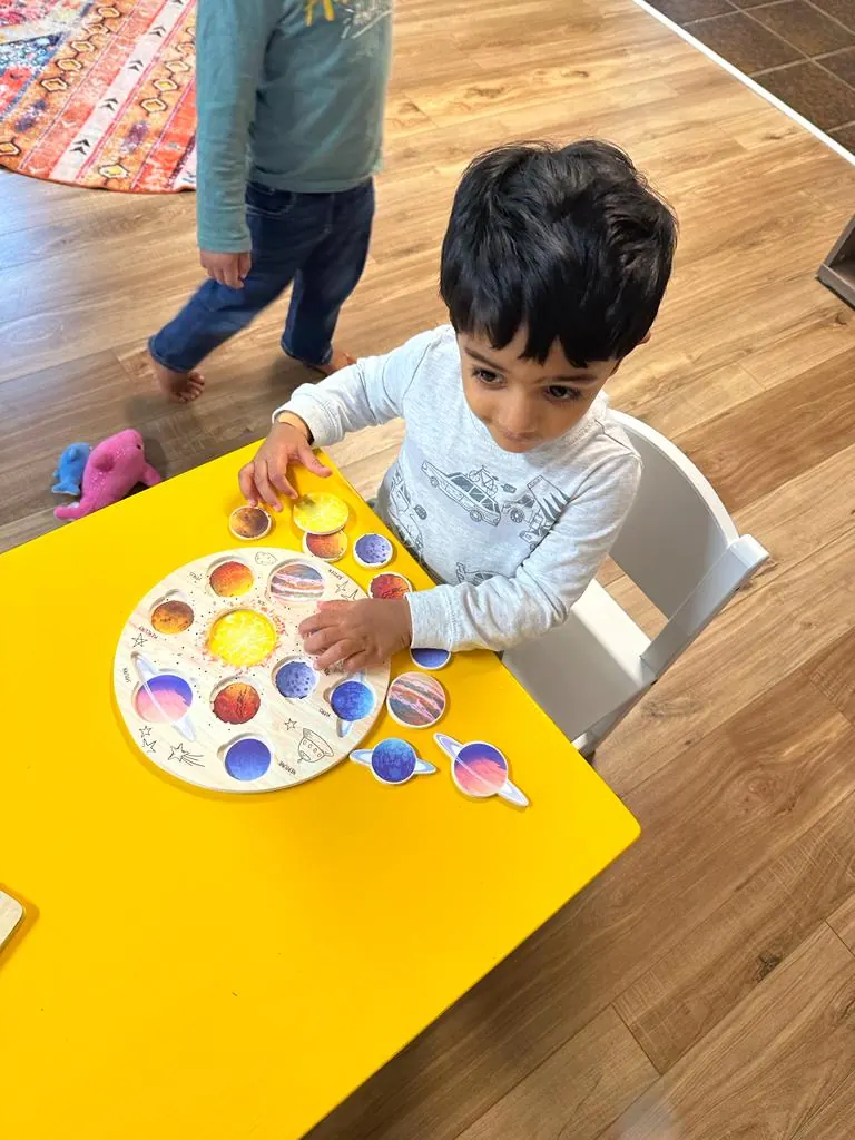A child exploring a solar system puzzle