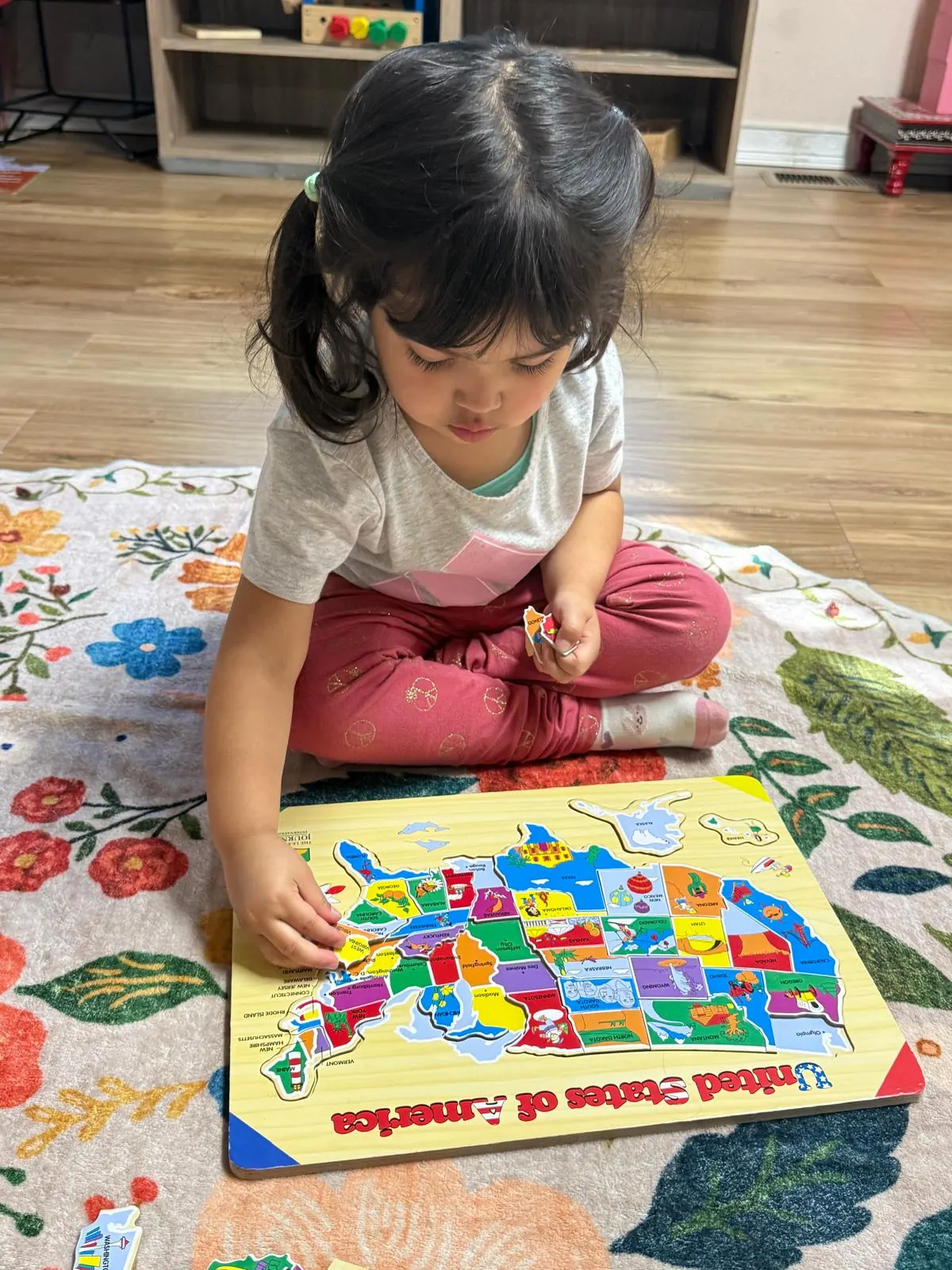 A girl fitting states into a United States map puzzle