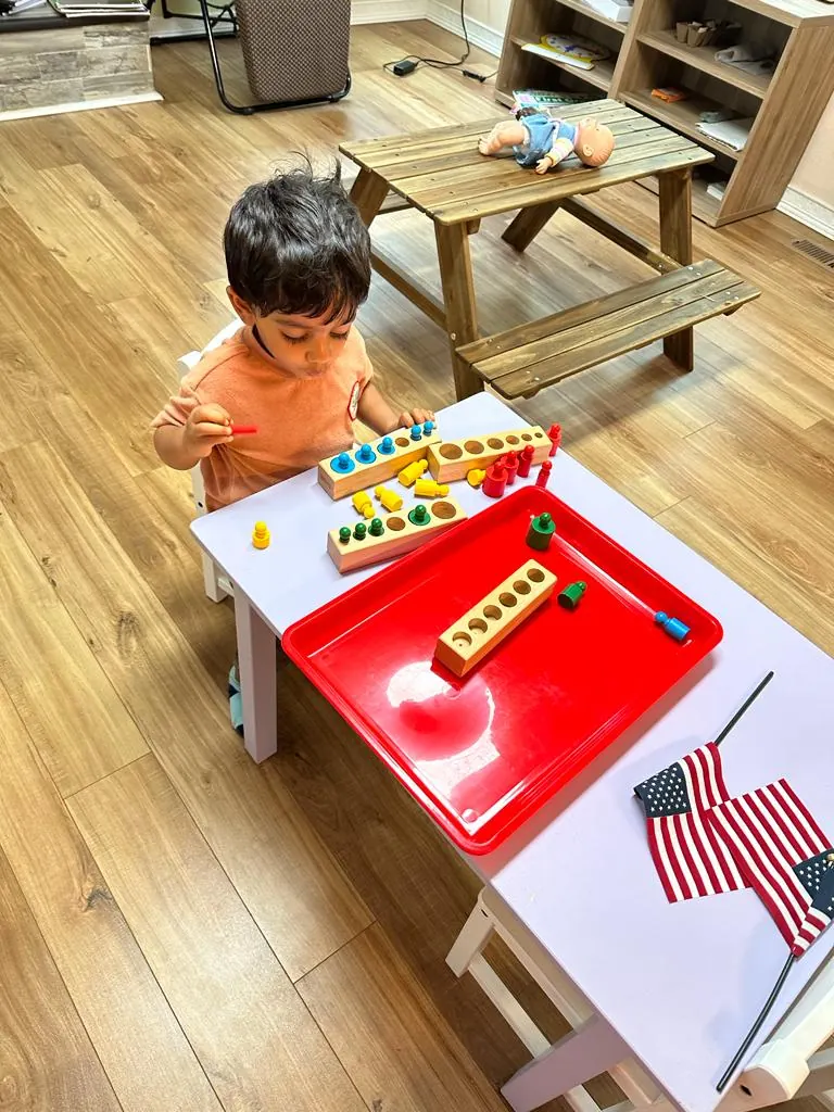 A child working with knobbed cylinder blocks