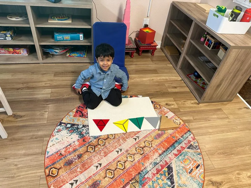 A child sorting coloured triangles on a work mat