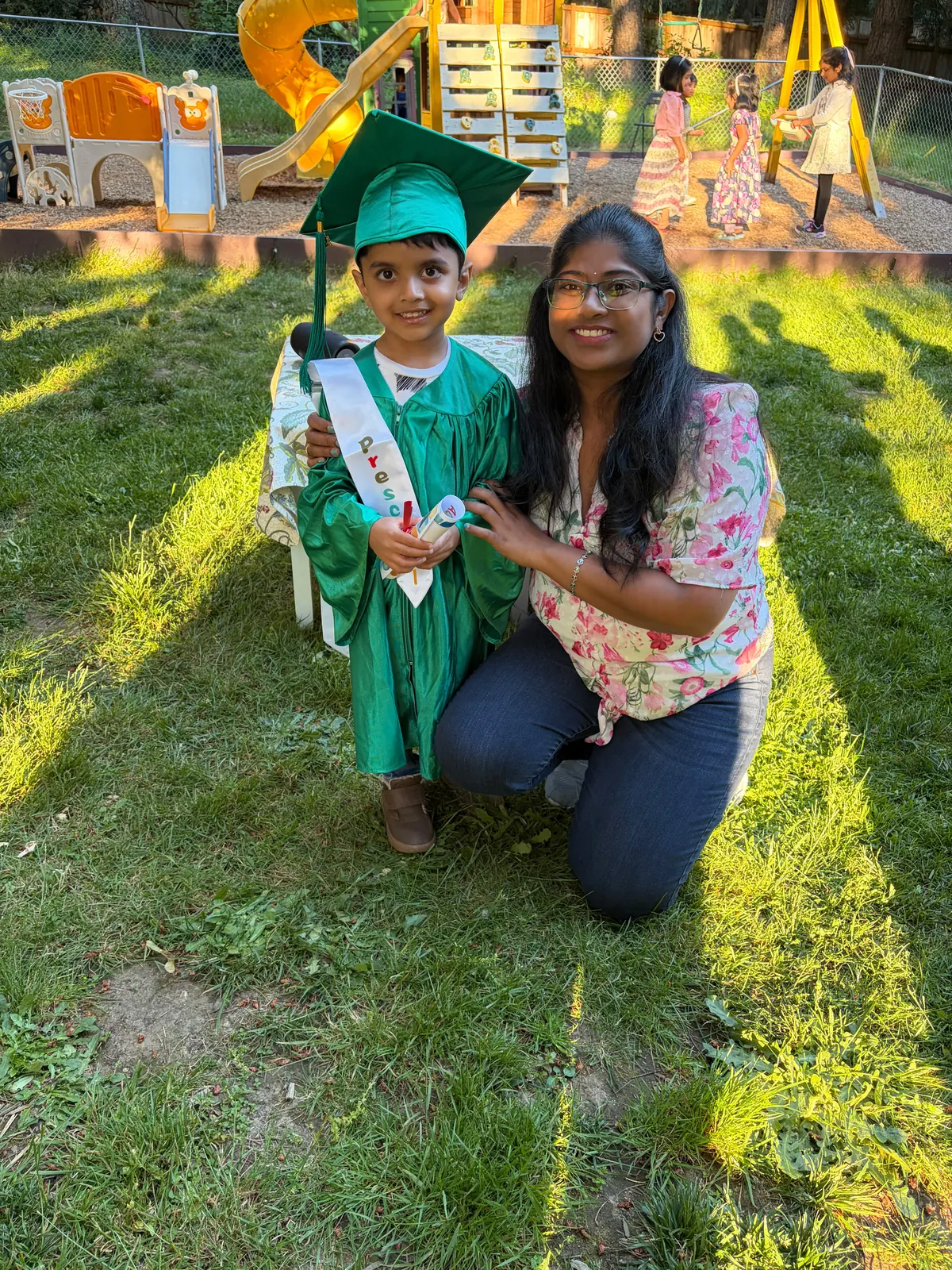 A beaming boy graduate with his teacher