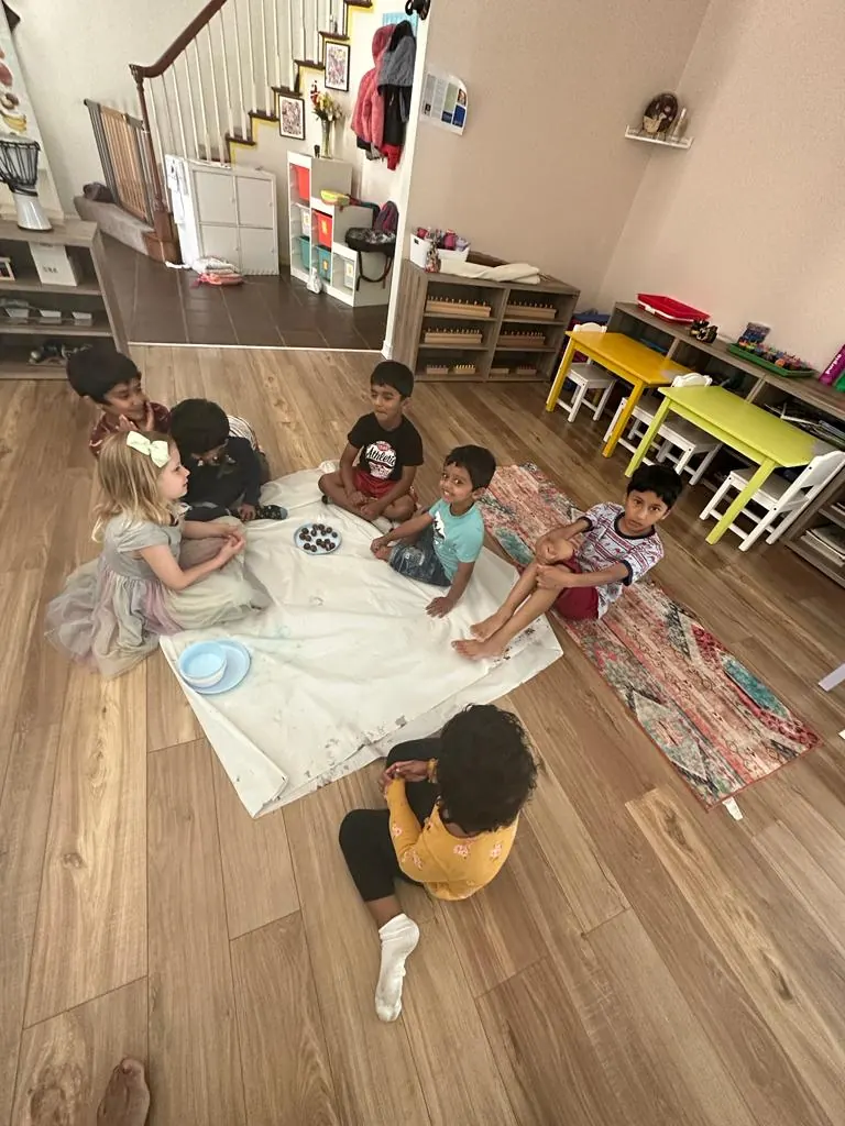 Children in a circle making date and nut laddoos