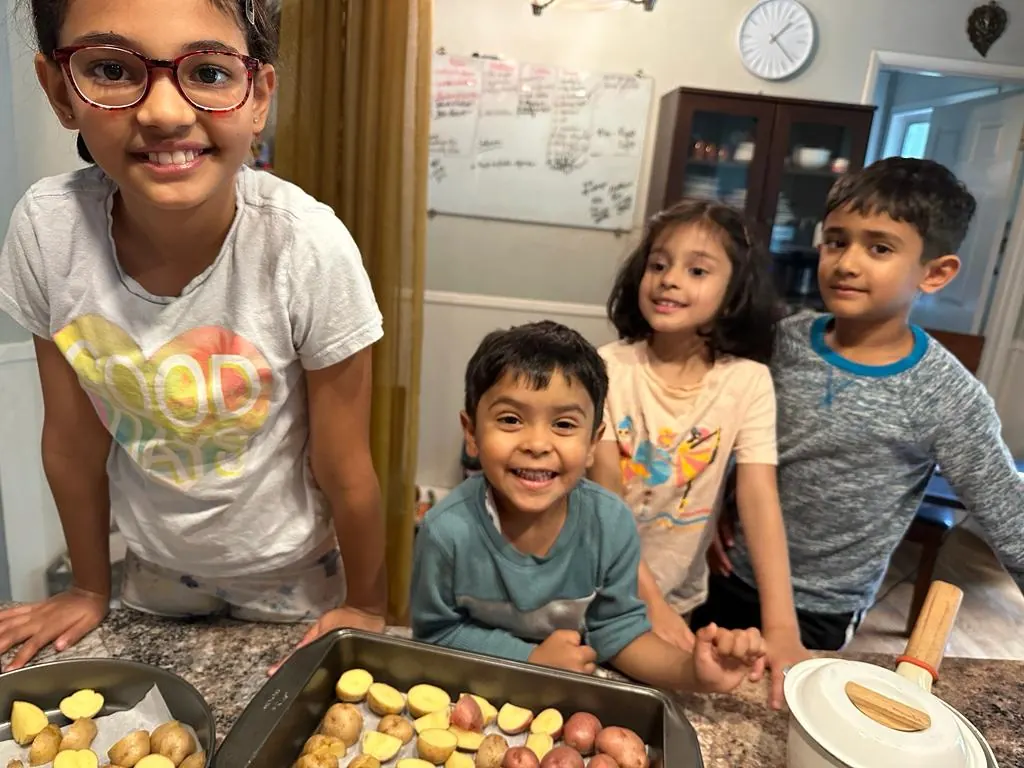 Children with a tray of potatoes they prepared